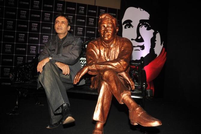 Dev Anand s son Suneil Anand posing with the brass statue of his late